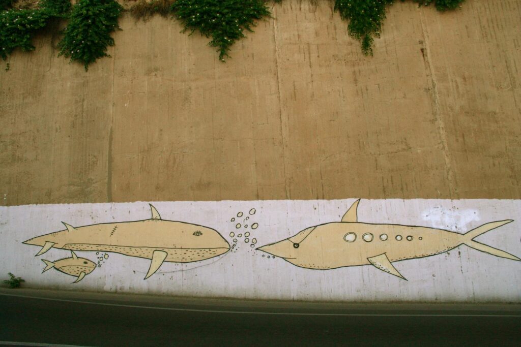 due balene stilizzate, disegnate su un muro del terrapieno del castello di Cagliari